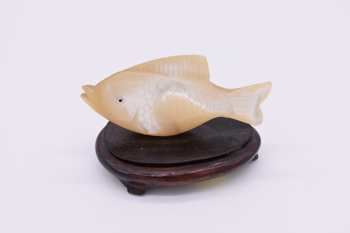 A Chinese carved mother-of-pearl fish, on wood base, 8.5cm long.