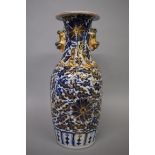 A Chinese blue and gilt twin handled vase, 19th century, relief decorated with chilong, 25cm high.