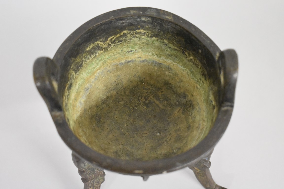 WITHDRAWN FROM SALE A Chinese Archiastic bronze twin handled tripod ding, with stylized decoration. - Image 4 of 6