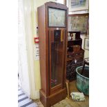 An Art Deco ebonized and oak eight day chiming longcase clock, having 12 x 9in silvered dial, with