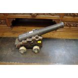 An old cast iron cannon, on wooden carriage, barrel length 39.5cm.