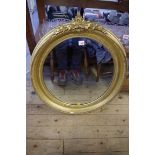 A 19th century gilt oval wall mirror, having grapevine surmount, 80cm high approx.