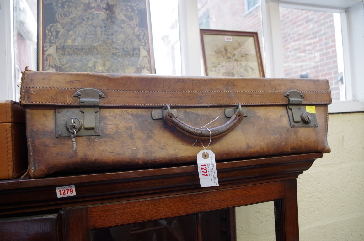An old leather suitcase, locked, 65cm wide.