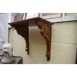 A Victorian walnut carved clock bracket, 43cm wide.