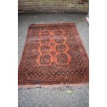 An old Afghan rug, having repeated medallions to central field, 200 x 140cm.