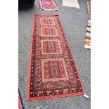 A Persian style runner, on a red ground, 250 x 80cm.