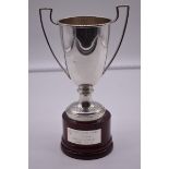 An Italian white metal twin handled trophy cup, stamped 925, on wood socle, 23.5cm total height.