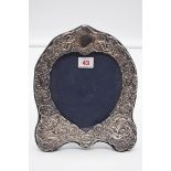 An embossed silver easel back photograph frame, by D R & S, London 1986, 26cm high.