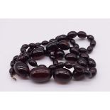 A string of graduated 'cherry amber' beads, 83cm, 73.5g.
