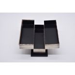 An Art Deco sterling silver hinged playing card box, on ebonised base, 22cm wide.