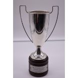 A continental white metal twin handled trophy cup, stamped 800, on wood socle, 31cm total height.