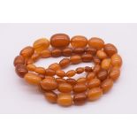 A graduated amber bead necklace, 76.5cm long, 52g.