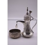 An Arabic white metal dallah, 20.5cm high; together with a similar small decorative bowl. (2)