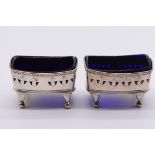 A pair of George III pierced silver salts, makers mark indistinct, London 1808, with blue glass