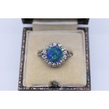An opal and collet set diamond ring, the unmarked platinum mount having diamond chip shoulders, 4g