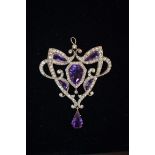 An Art Nouveau amethyst and diamond pendant, the unusually cut amethysts sinuously surrounded with