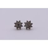 A pair of unmarked diamond cluster ear studs, 3.2g total weight.