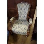 A Victorian carved walnut and button upholstered open arm occasional chair.