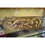 An Arts and Craft embossed brass dragon doorplate, 30cm wide.