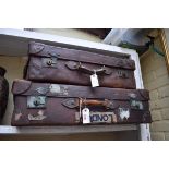Two vintage leather suitcases, largest 77cm wide.