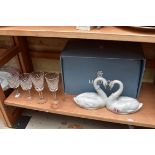 A Lladro swan figure group, boxed; together with four Waterford glasses.