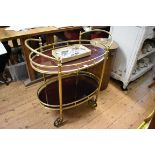 A 1960s brass and mahogany oval two tier trolley, 74cm wide.