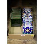 A set of twenty-two Spanish green glazed tiles, 11cm square; together with another set of twenty-