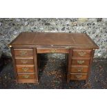 A 1930s desk having nine drawers, 136cm wide. This lot can only be collected on Saturday 5th