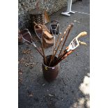 A barrel stick stand containing four shooting sticks, four walking sticks and a malacca officer's