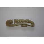 A Chinese carved celadon jade dragon and lingzhi belt buckle, 11.5cm long.