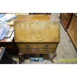 A 1930s burr walnut bureau, on cabriole legs, 69cm wide.