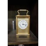 An Angelus brass carriage timepiece, height including handle 17.5cm, with winding key.