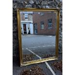 A large reproduction gilt framed wall mirror, 136 x 106cm. This lot can only be collected on