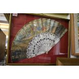 An antique fan, with pierced mother-of-pearl sticks and printed decoration, the guards 27cm,