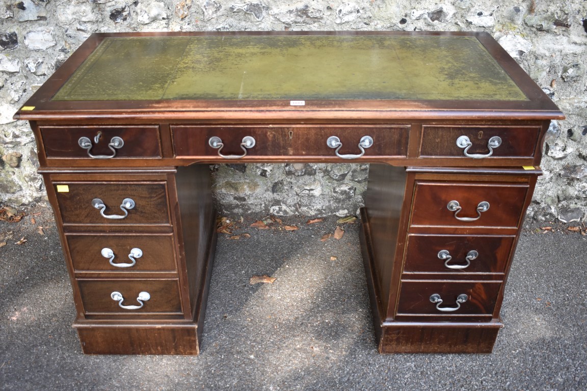 A reproduction mahogany veneered kneehole desk, having green leather inset top, 123cm wide. This lot