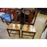 A pair of 18th century oak dining chairs, each with vase shaped splat and solid seat.