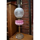 An old brass and pink glass oil lamp.
