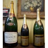 Three large shop window champagne display bottles, comprising: a 12 litre Laurent Perrier; a 6 litre