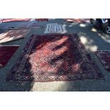 A large Persian rug, having three central diamond medallions, with animals and flowers to central