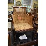 A Regency mahogany and cane bergere chair.