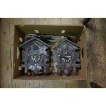 Two carved wood cuckoo clocks, each with weight.