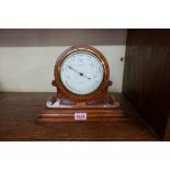 An oak cased aneroid barometer, 20cm high.