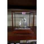 A Japanese silver and silver plated model yacht, by Seki, in glass case, the case 23cm high x 23cm