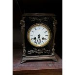 An antique ebonized and brass mounted mantel clock, striking on a bell, 26cm high, with key.