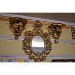 A carved giltwood framed wall mirror, 51 x 36cm; together with a pair of carved giltwood wall