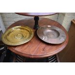 An old small brass alms type dish, 30.5cm diameter; together with another copper dish, embossed with