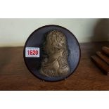 A gilt metal portrait relief plaque of Horatio Nelson, 11cm high, on composition circular plaque.