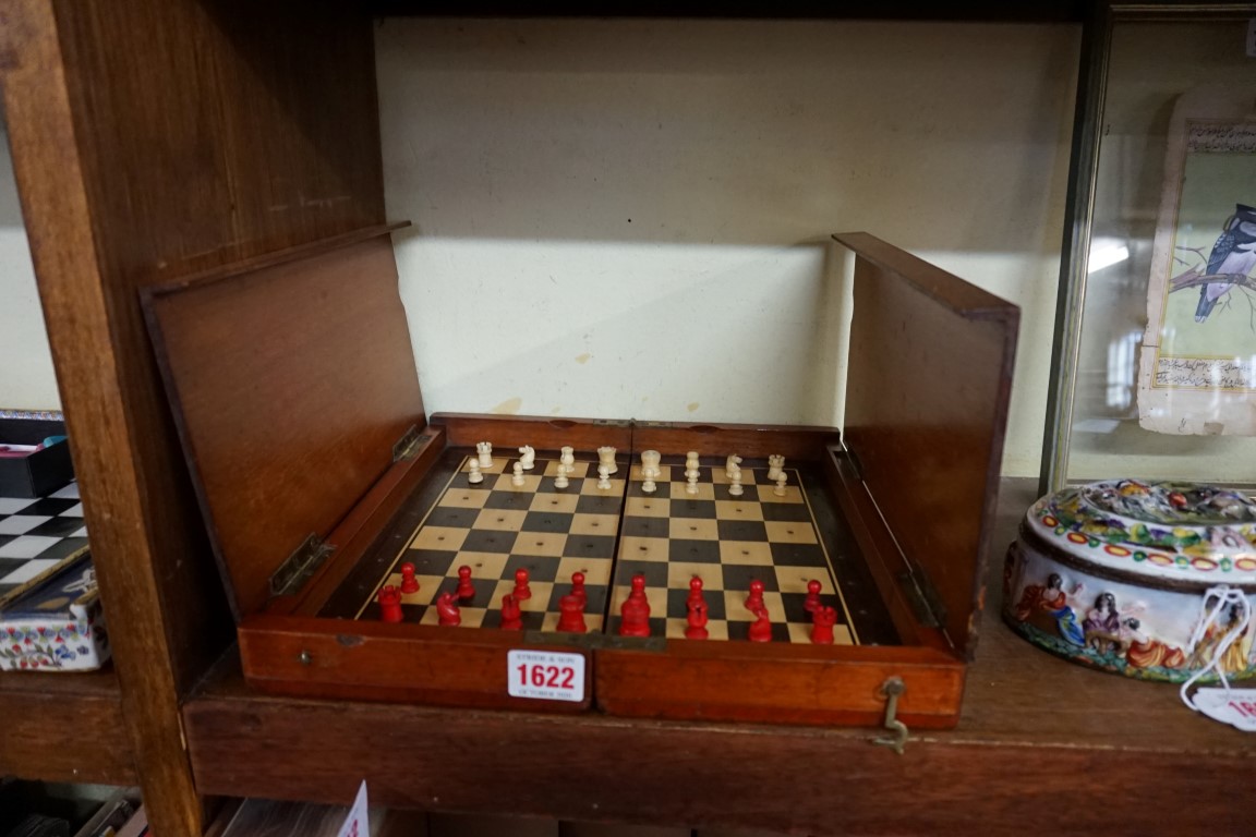 A Victorian mahogany folding chessboard, with bone chess set, the board 30.5cm wide.