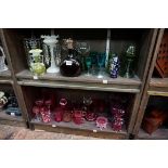 A large collection of coloured glass. (2 shelves)