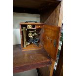 A brass monocular microscope, in mahogany case.